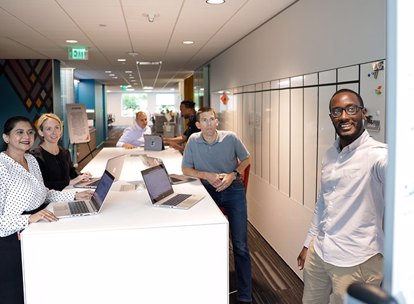 Group Of Colleagues Discussing Content On Whiteboard